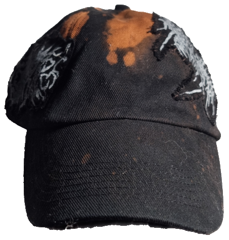 A black baseball cap with orange and white graphics, including text, and a distressed, worn appearance.