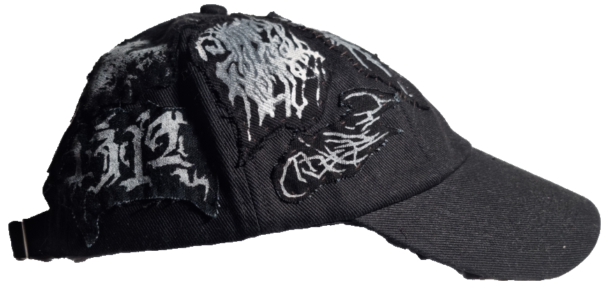 Black baseball cap with white graffiti-style graphic designs on the front and side panels.