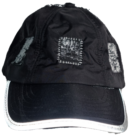 Black baseball cap with white distressed patches and a white brim.