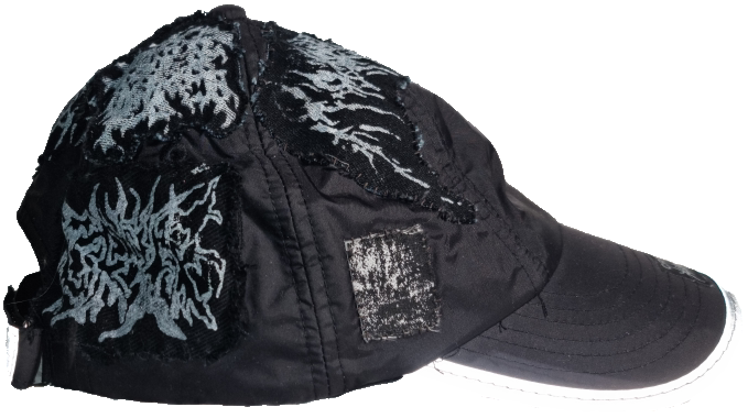 A black baseball cap with white distressed graphic designs and patches.