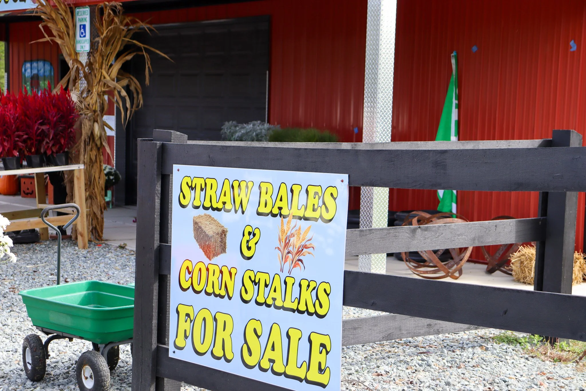 A sign advertising straw bales and corn stalks for sale at Sunny Dreams Farm during the fall season.