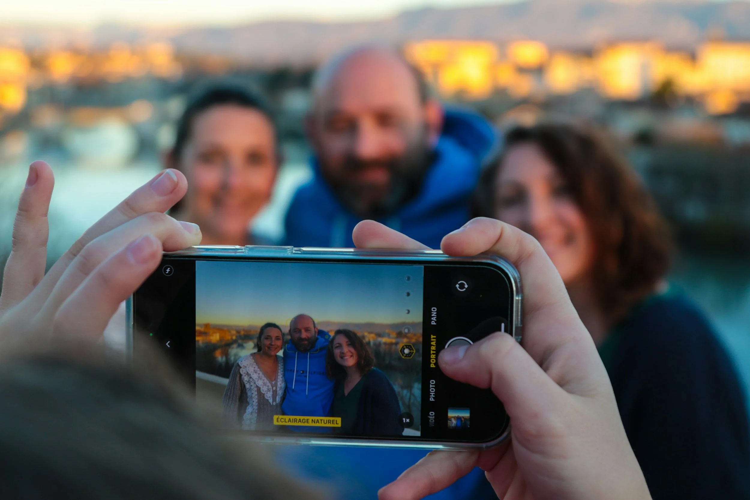 Someone taking photo of three persons on their mobile