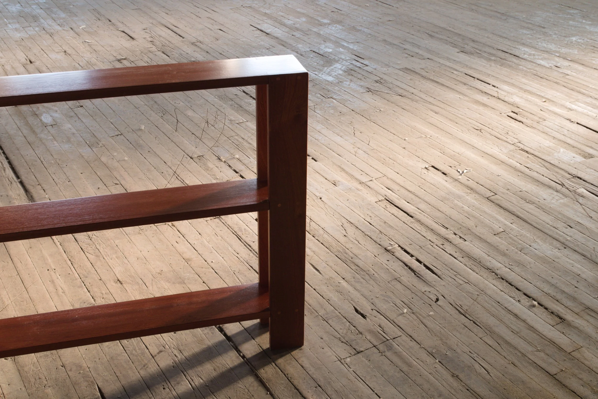 Part of a wooden table or bench with empty wooden floor visible.