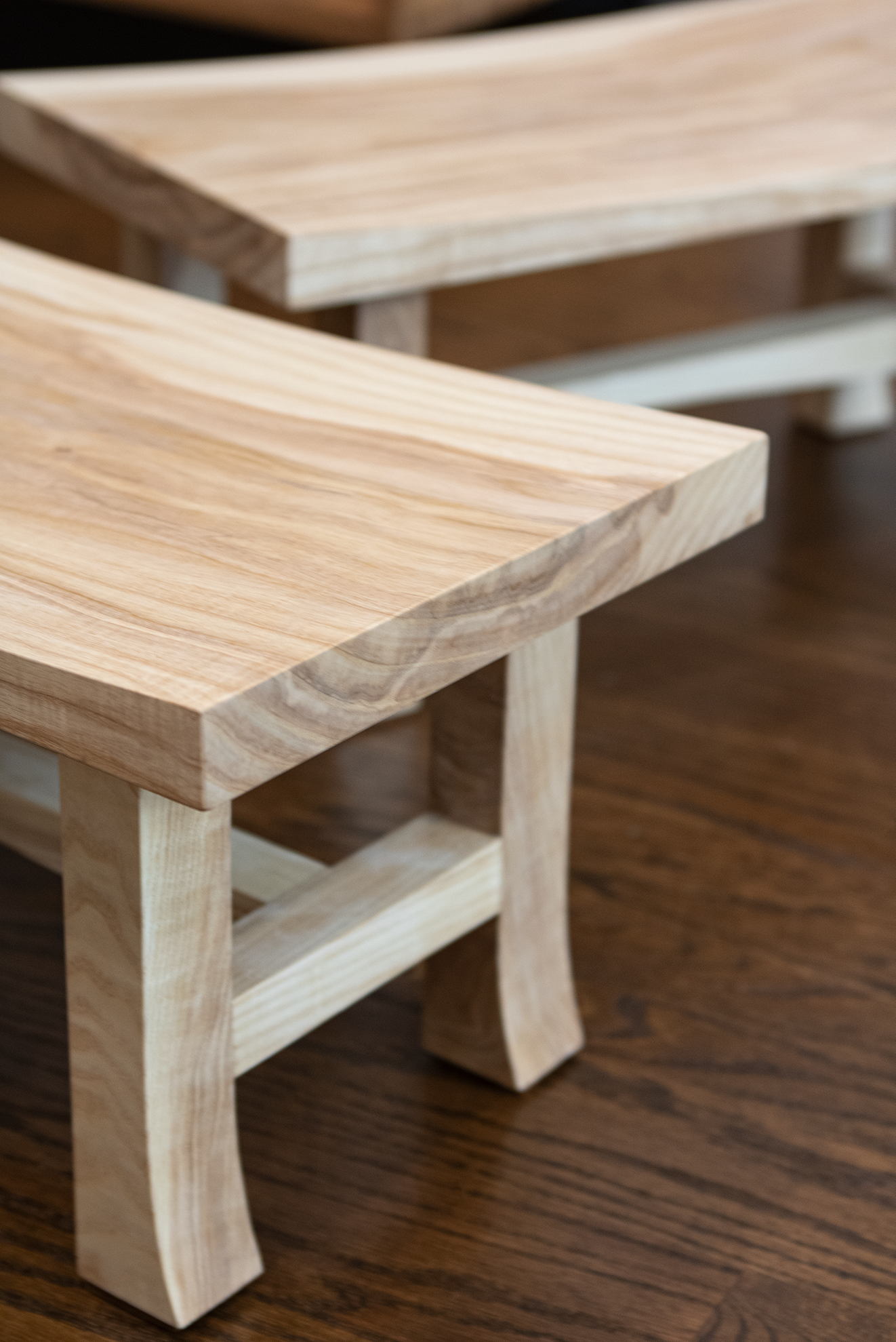 Close-up view of small wooden tables with natural wood finish on a wooden floor.