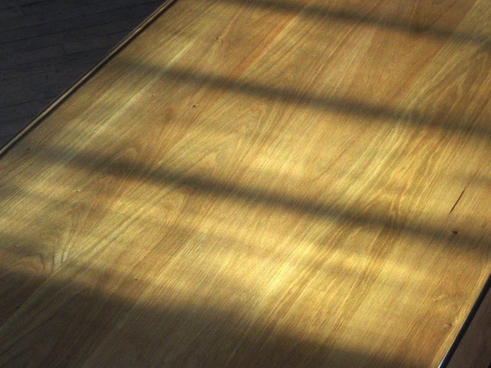 Sunlight casting shadows across a wooden surface.