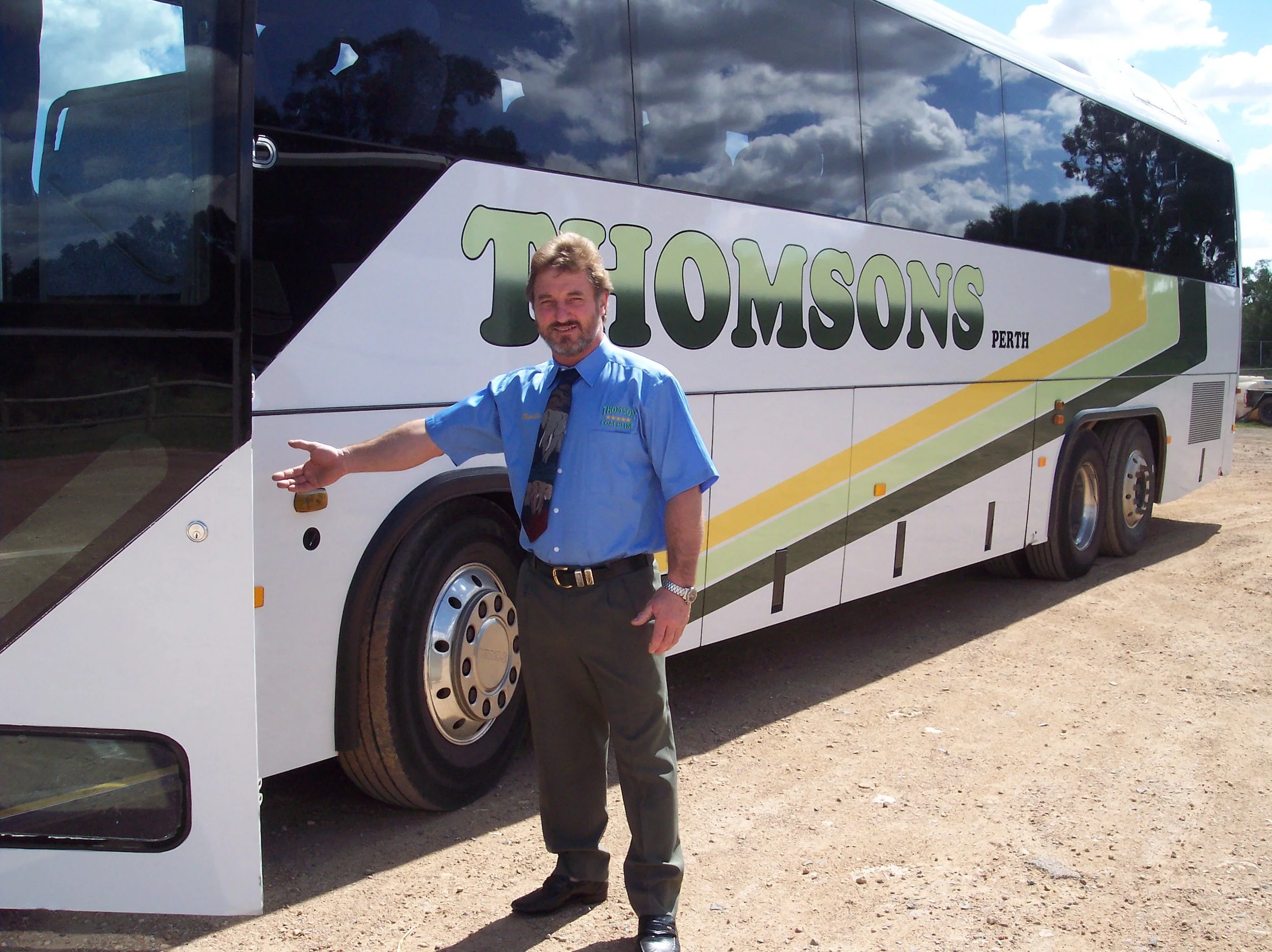 Neville Thomson (#8) Standing in front of 48 seat coach.jpg