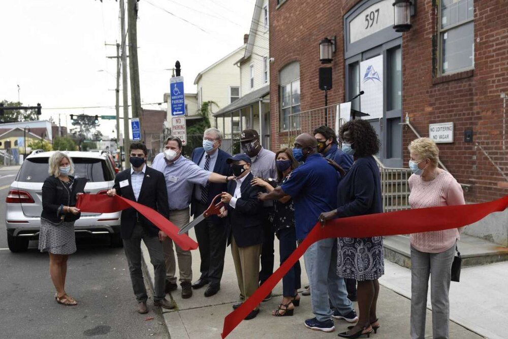  Pacific House Executive Director Rafael Pagan Jr. cuts the ribbon along with local officials and Pacific House staff at newly-renovated building in Stamford, Conn. Monday, Sept. 29, 2020. The men's emergency shelter held a ribbon cutting Tuesday for
