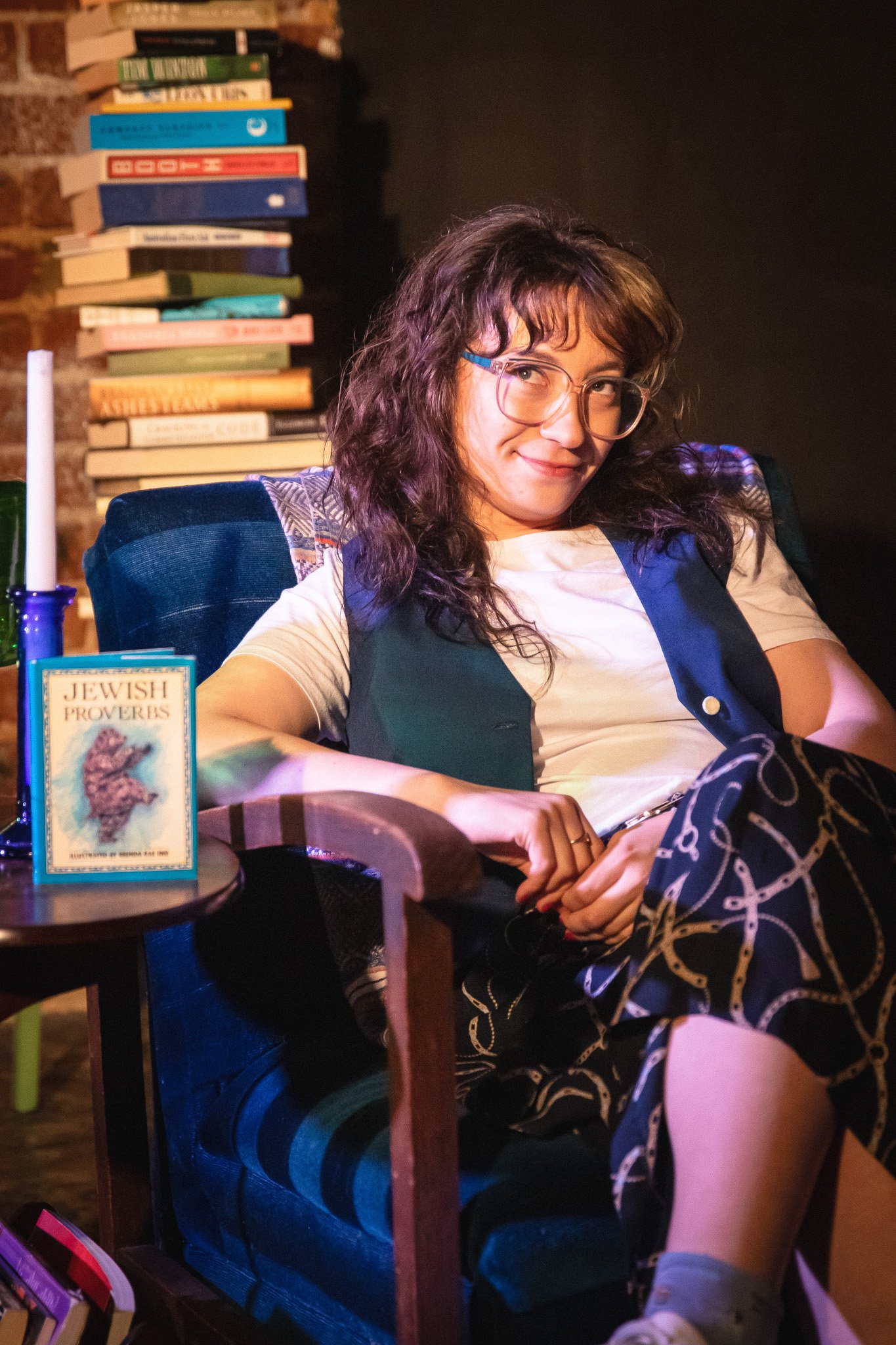 Production photo from “NUSIA,” a one-woman show by A Ry Presentation, featuring the performer mid-monologue as she explores themes of identity, cultural inheritance, and personal reawakening. Dramatic stage lighting highlights her emotional expressio