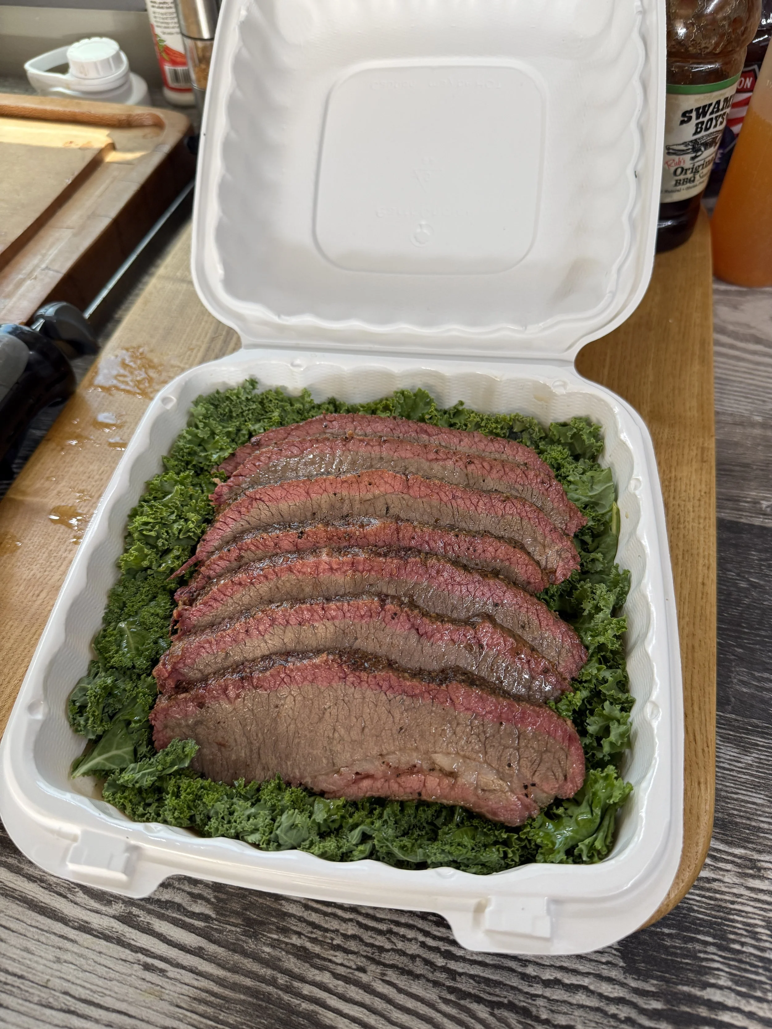 Competition submission of smoked beef brisket on a bed of greens.