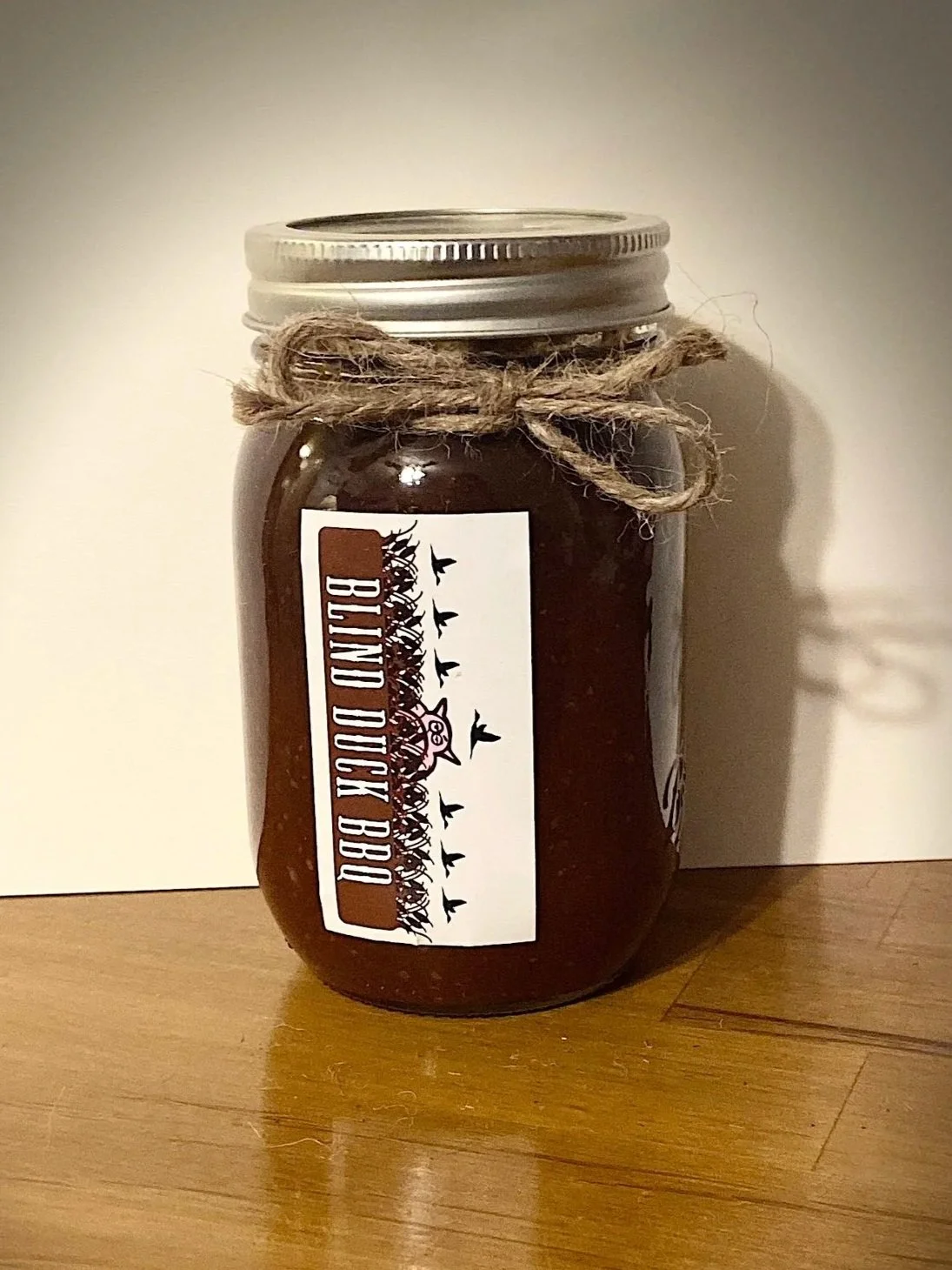 A glass pint jar of Blind Duck BBQ original BBQ sauce.