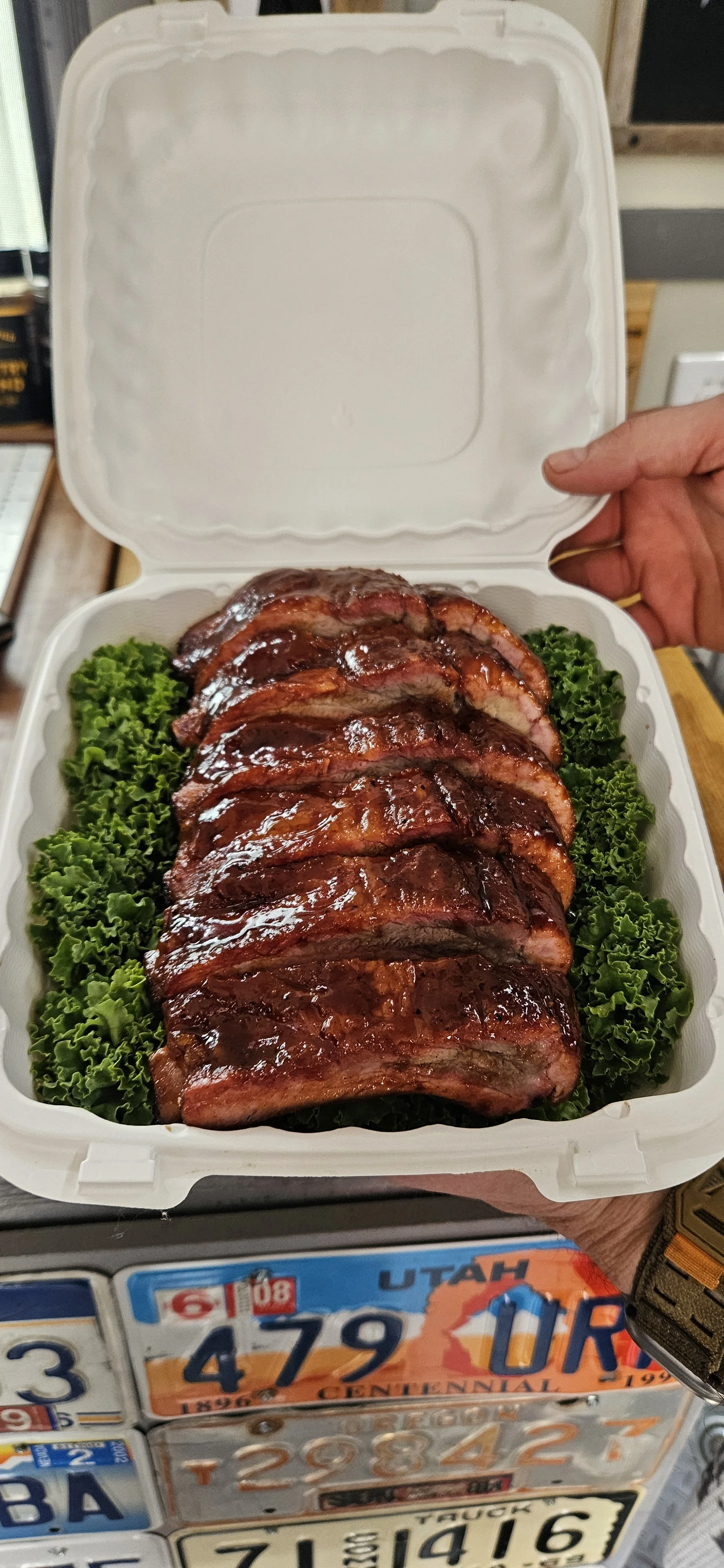 Competition submission of smoked pork ribs on a bed of greens.