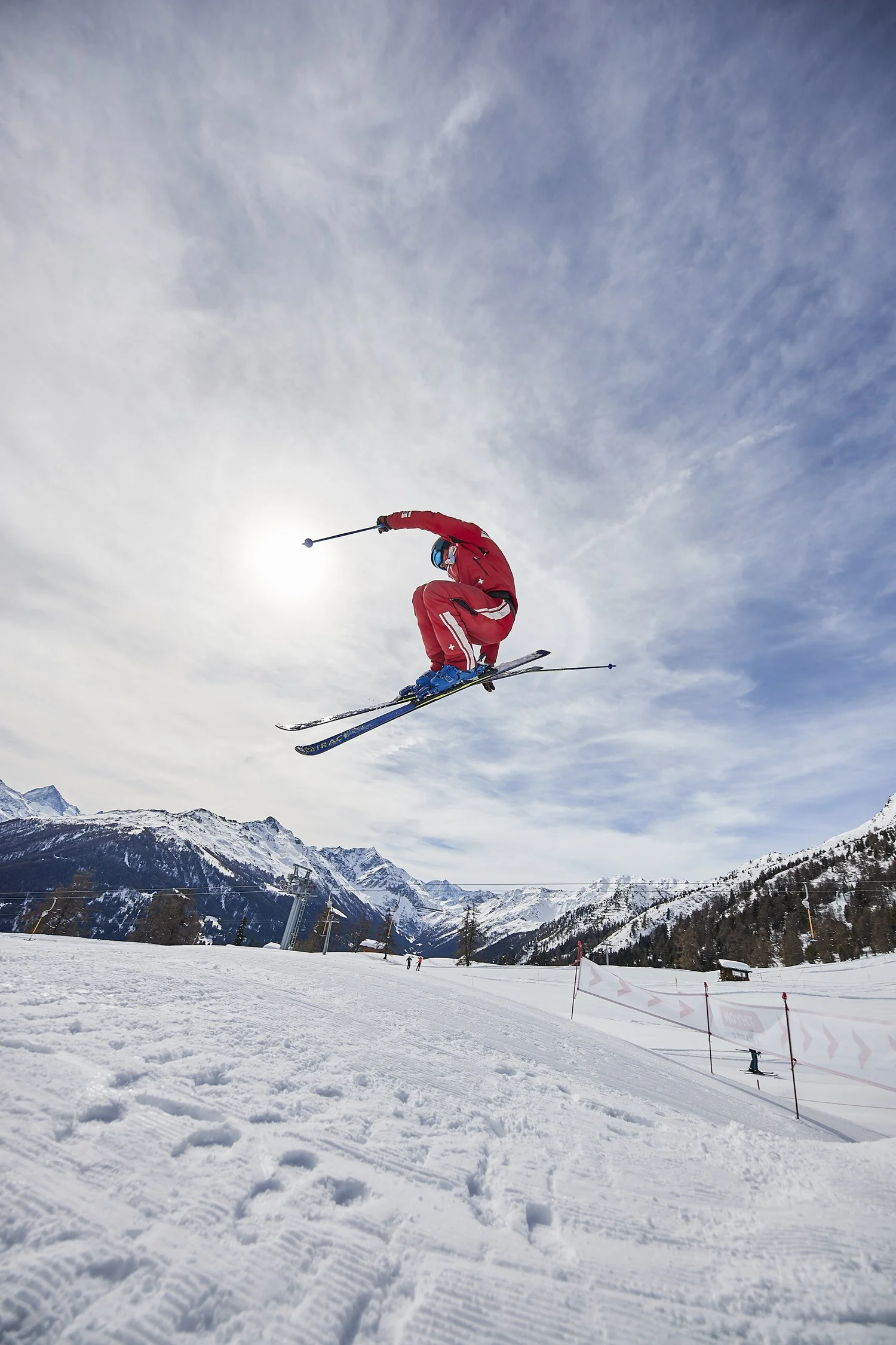 Skier in red turning through powder spray — Snow series — photograph by Michaël Gramm