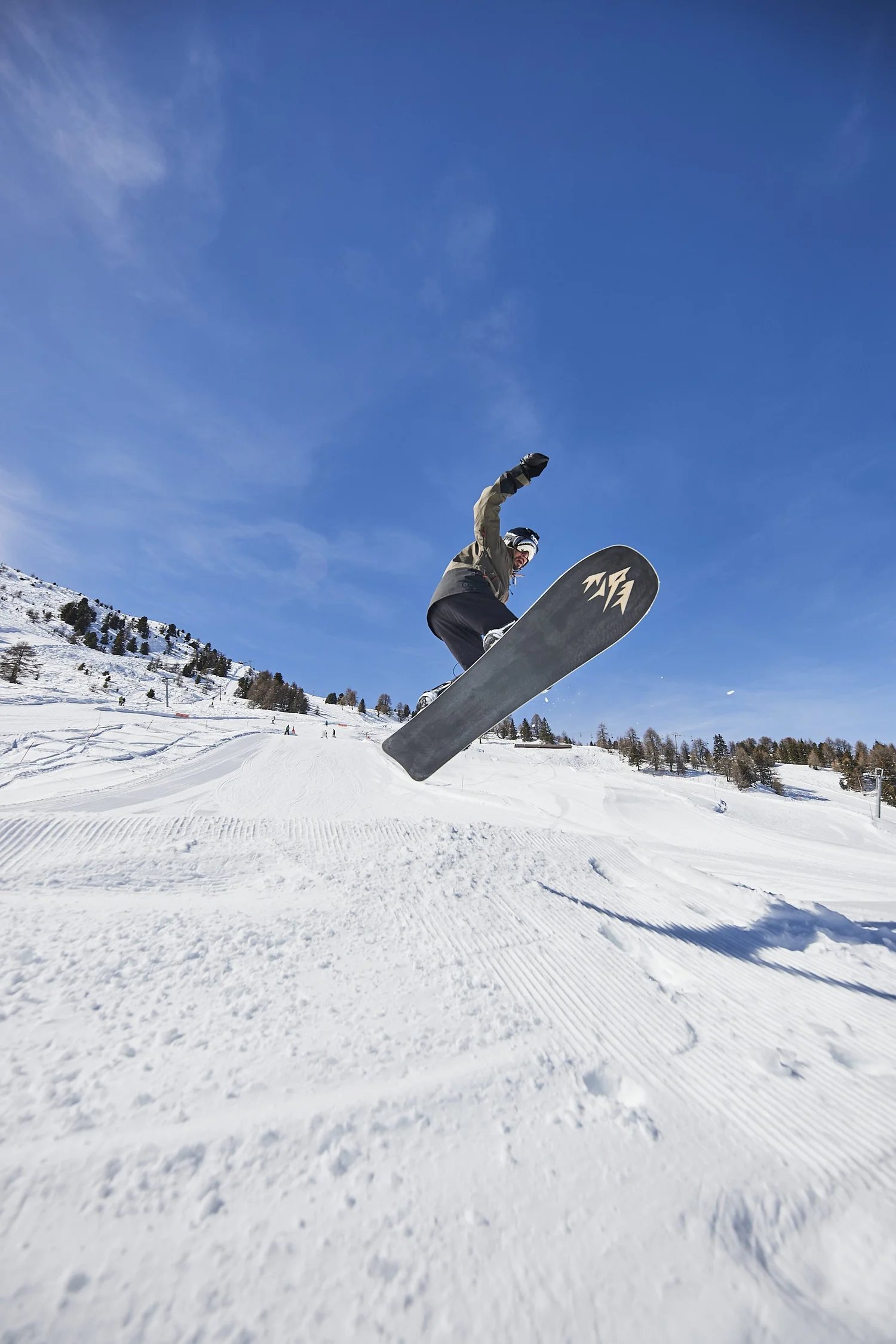 Snowboarder holding the board above a snow ramp — photograph by Michaël Gramm