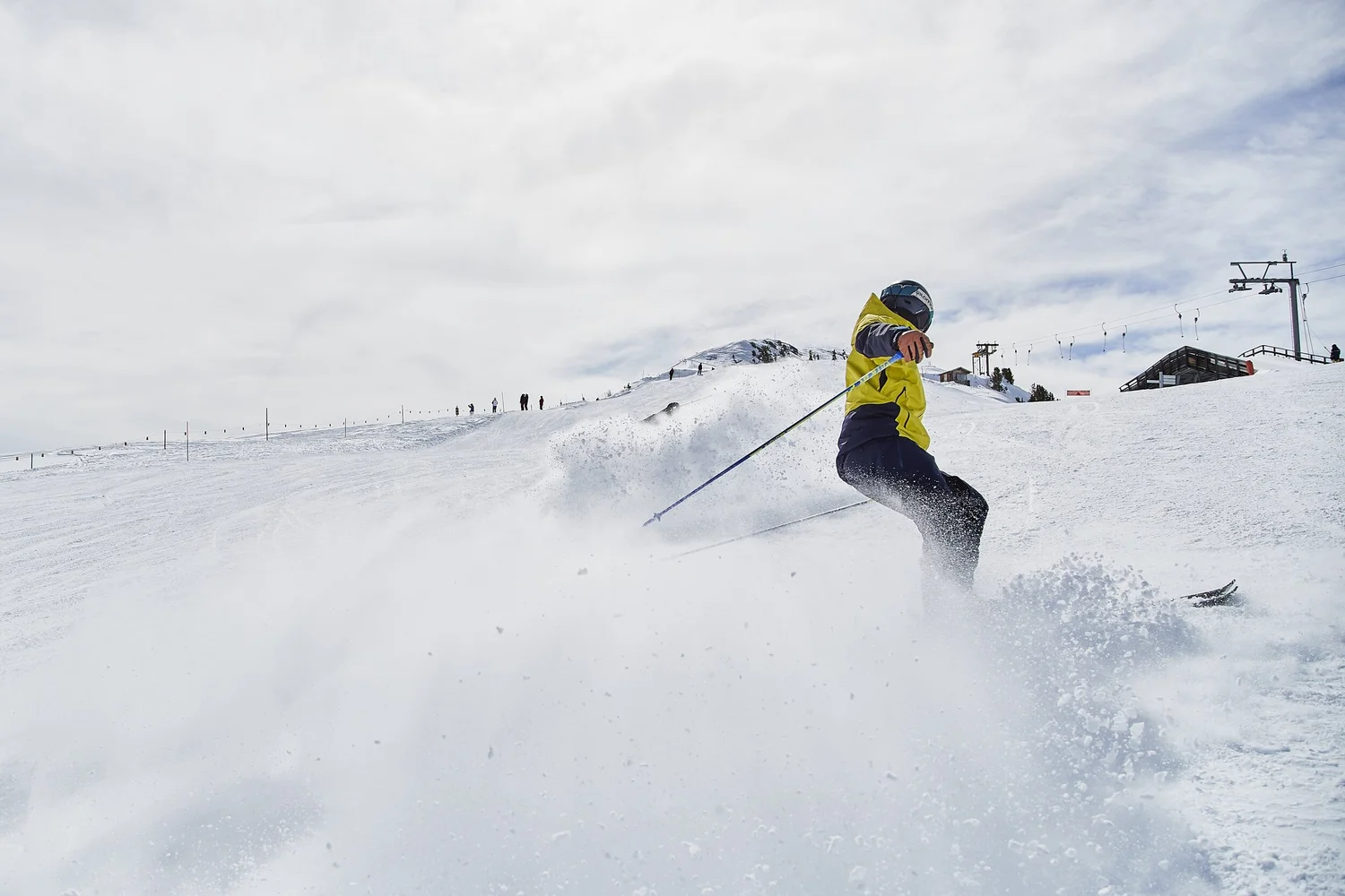 Skier throwing up powder on a broad snowy slope — photograph by Michaël Gramm