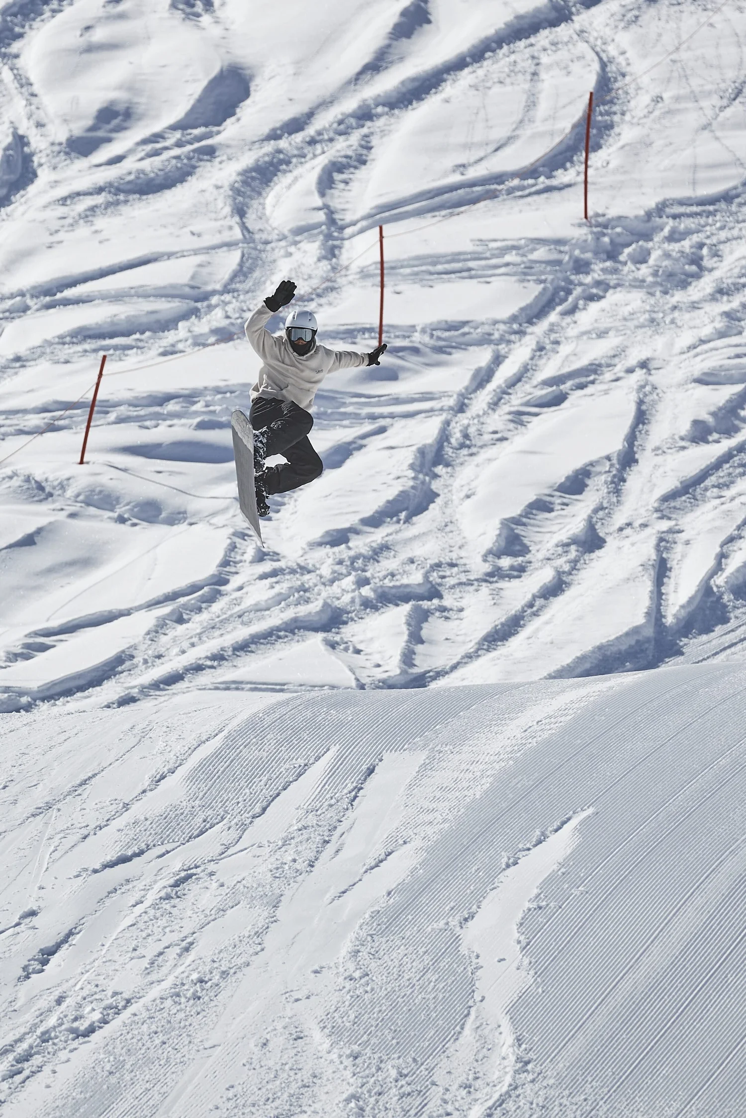 Skier descending across a tracked snowfield — photograph by Michaël Gramm