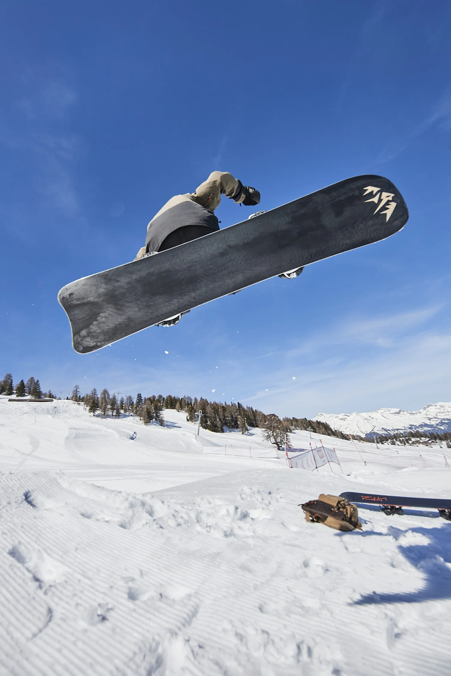Snowboarder airborne with the board in the foreground — photograph by Michaël Gramm