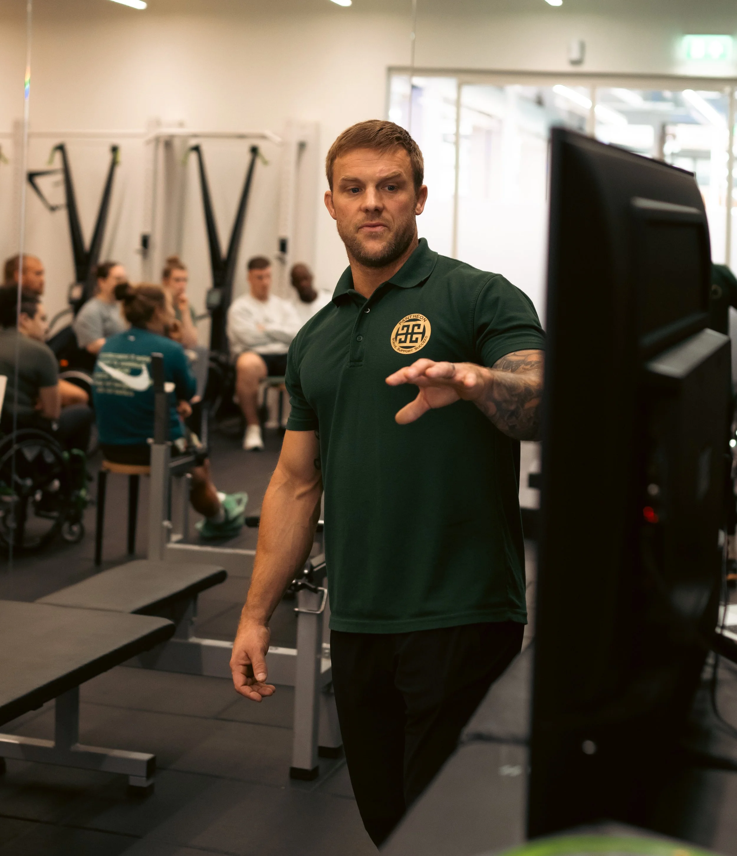 Personal trainer reviewing personalised fitness programming and performance data at Pantheon Plymouth gym, creating tailored exercise plans to help members achieve their health and fitness goals.