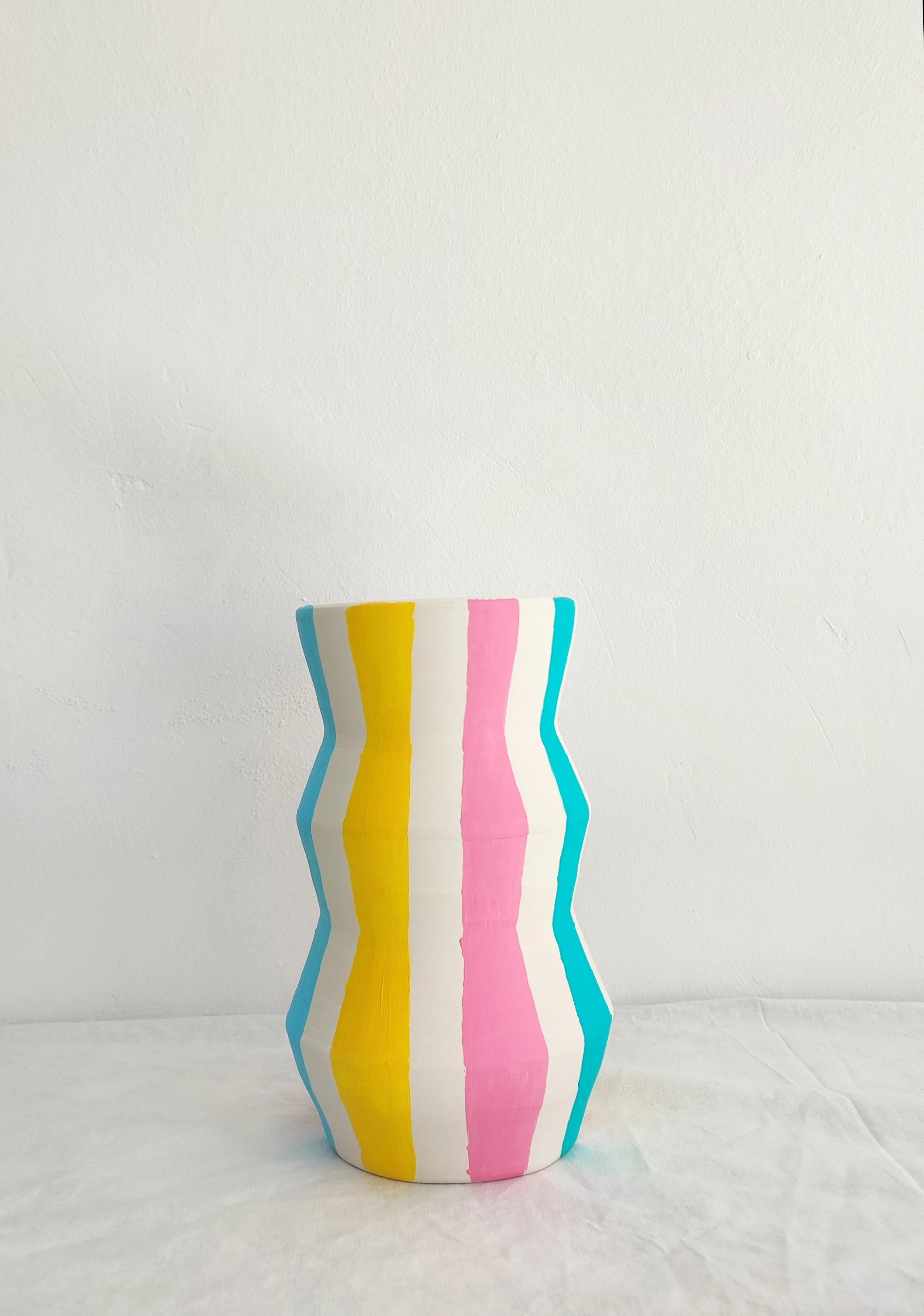 Jarrón blanco hecho y decorado a mano con rayas multicolor