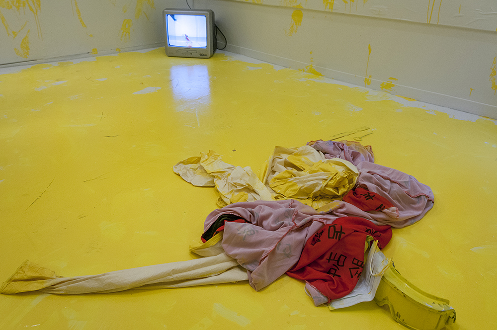  Marking.&nbsp;  Multimedia installation: yellow paint, oriental kimono, Coverall, googles, face mask, paint can, paint opener, documented performance, and television sets.&nbsp;  96x125x96 inches.  Installation view. 