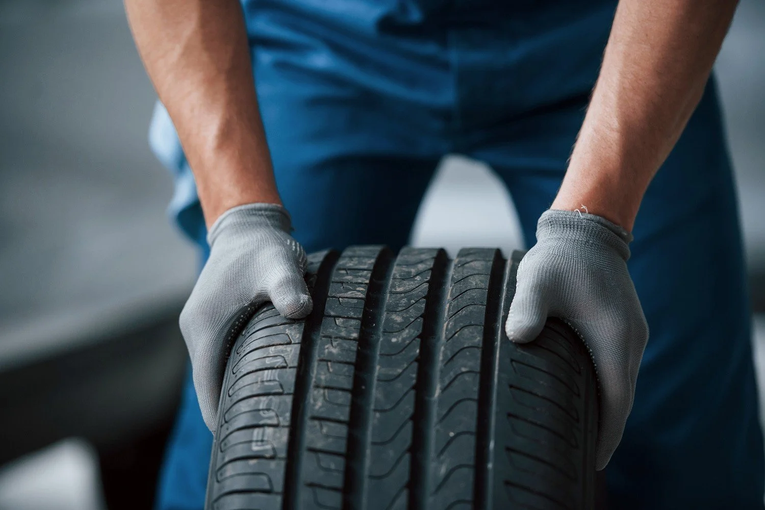 Technician holding a tire in a service garage