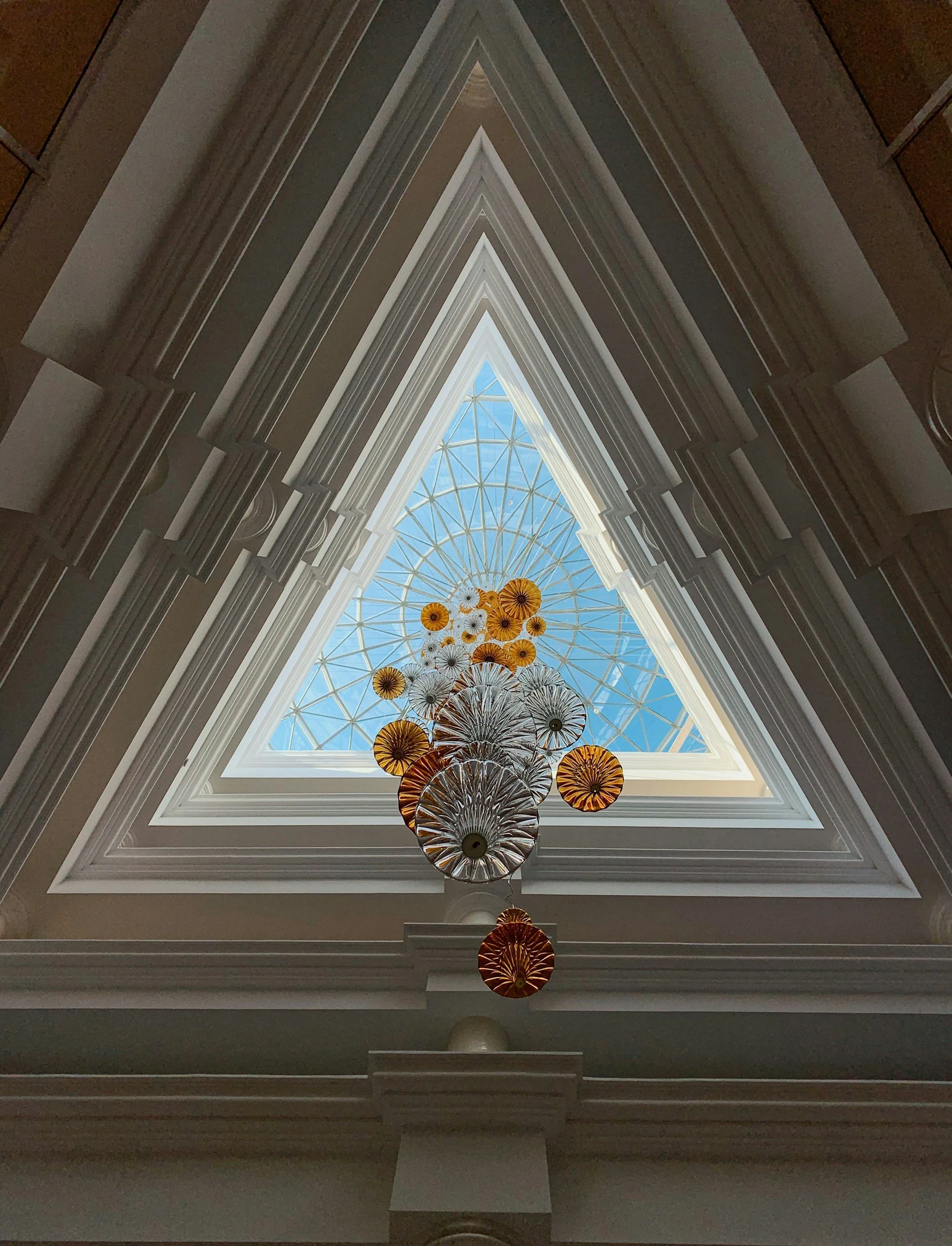 Triangular skylight with a hanging sculptural installation inside a modern building