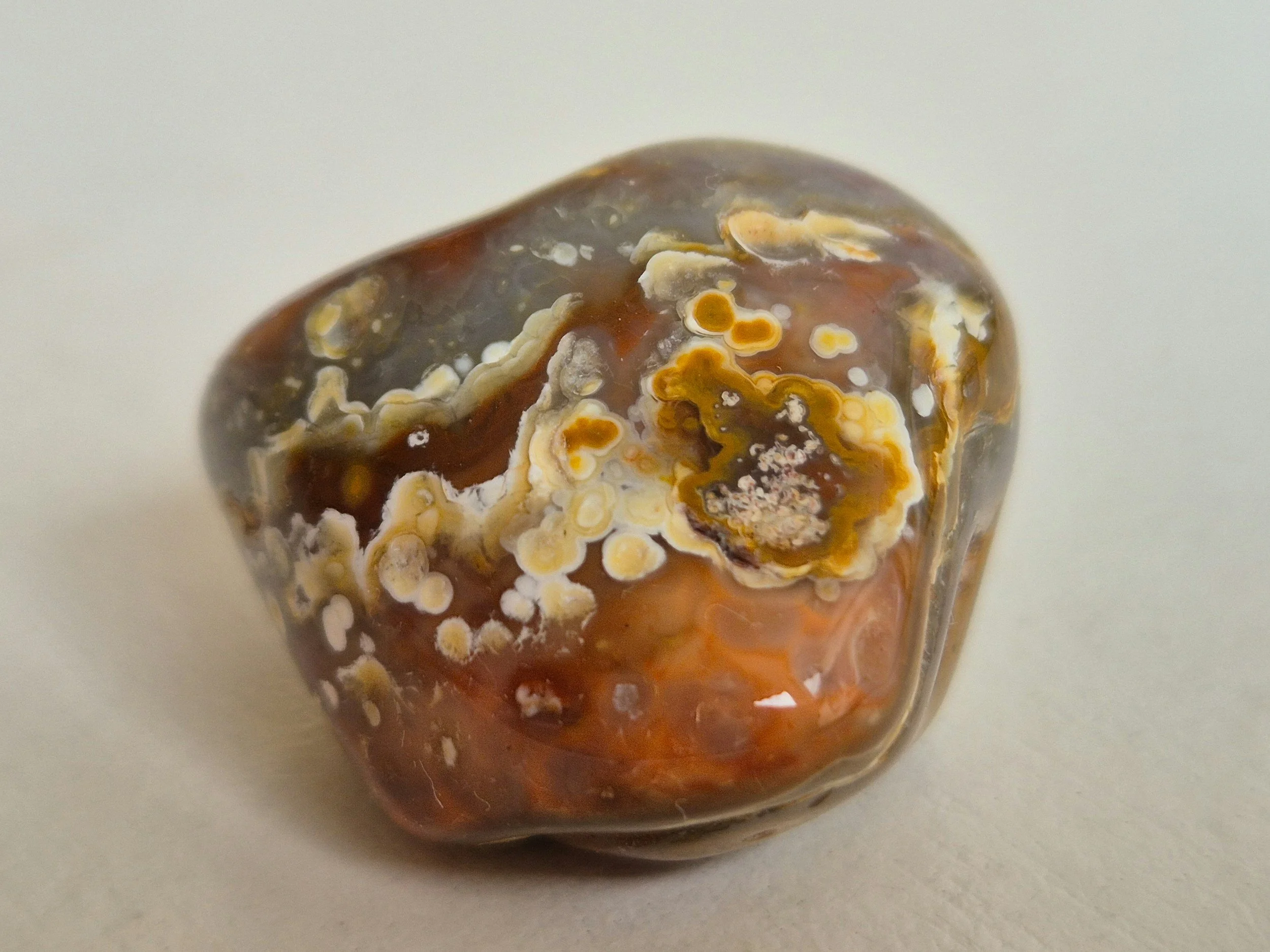 Polished stone with layered natural patterns resting on a light background