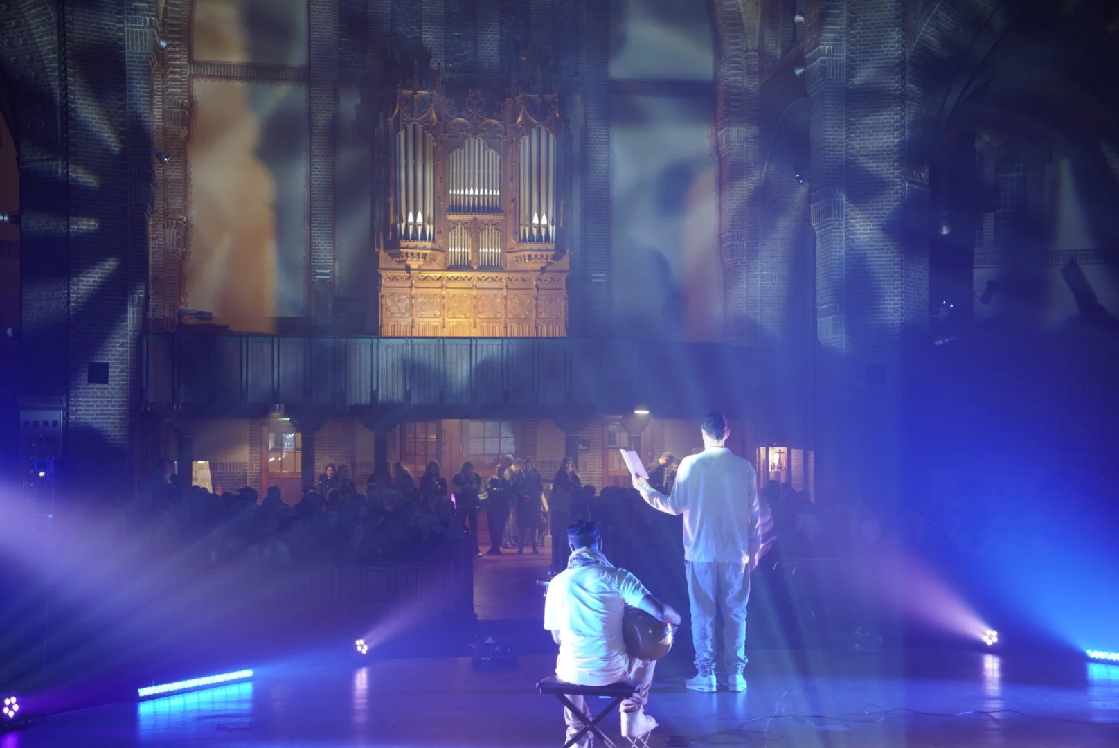 Avi Kishna performing sarod with a vocalist in a church venue.