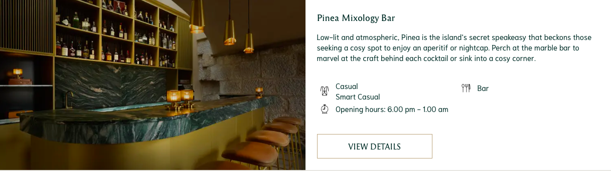 A low-lit cocktail bar with a marbled green bartop, gold pendant lights and drinks lining the wall.