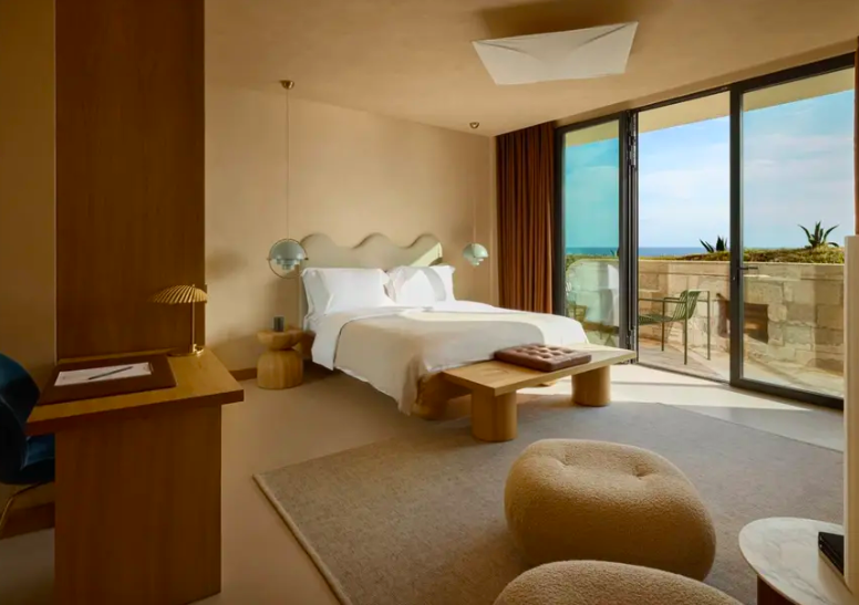 Banyan Tree elegant room suite with softly shaped furniture and windows that open to a sea-view balcony.