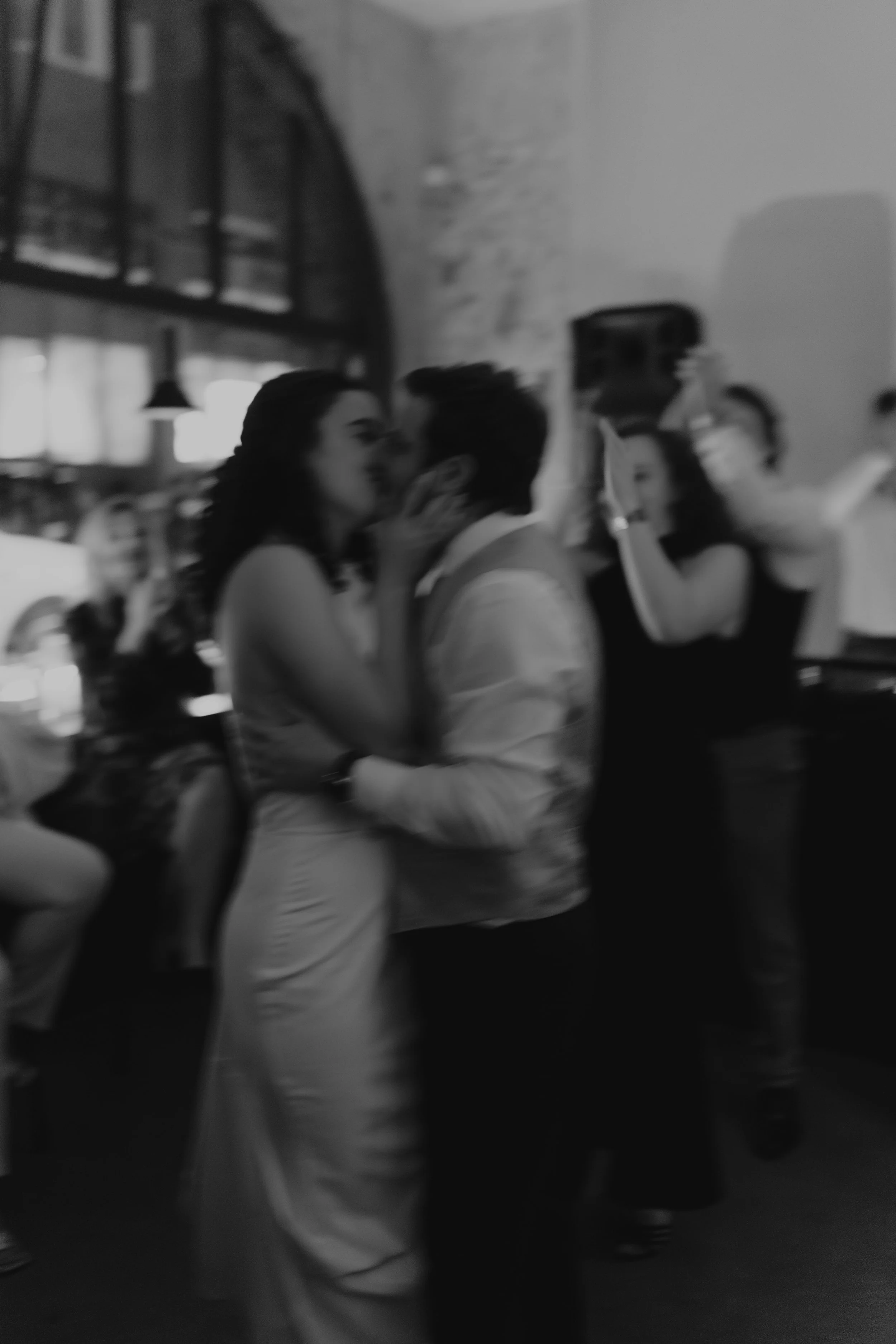 Paare tanzen im stilvollen, urbanen Ambiente bei einer Feier, schwarz-weiß fotografiert.