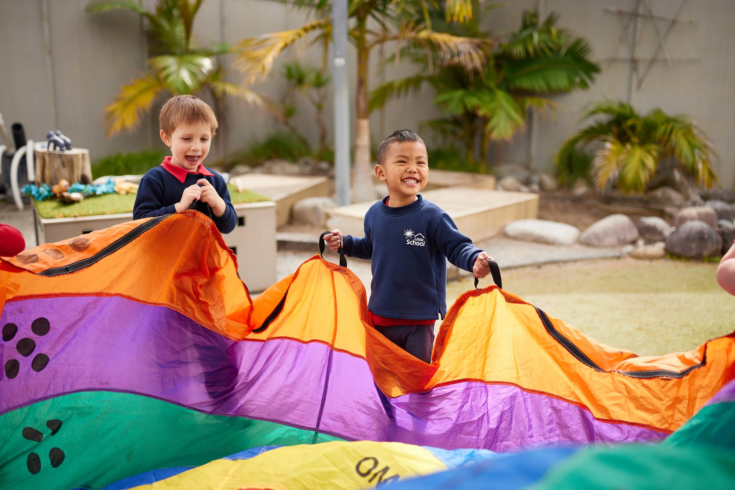 An image of two boys carrying something heavy with full of smile and engaging activity