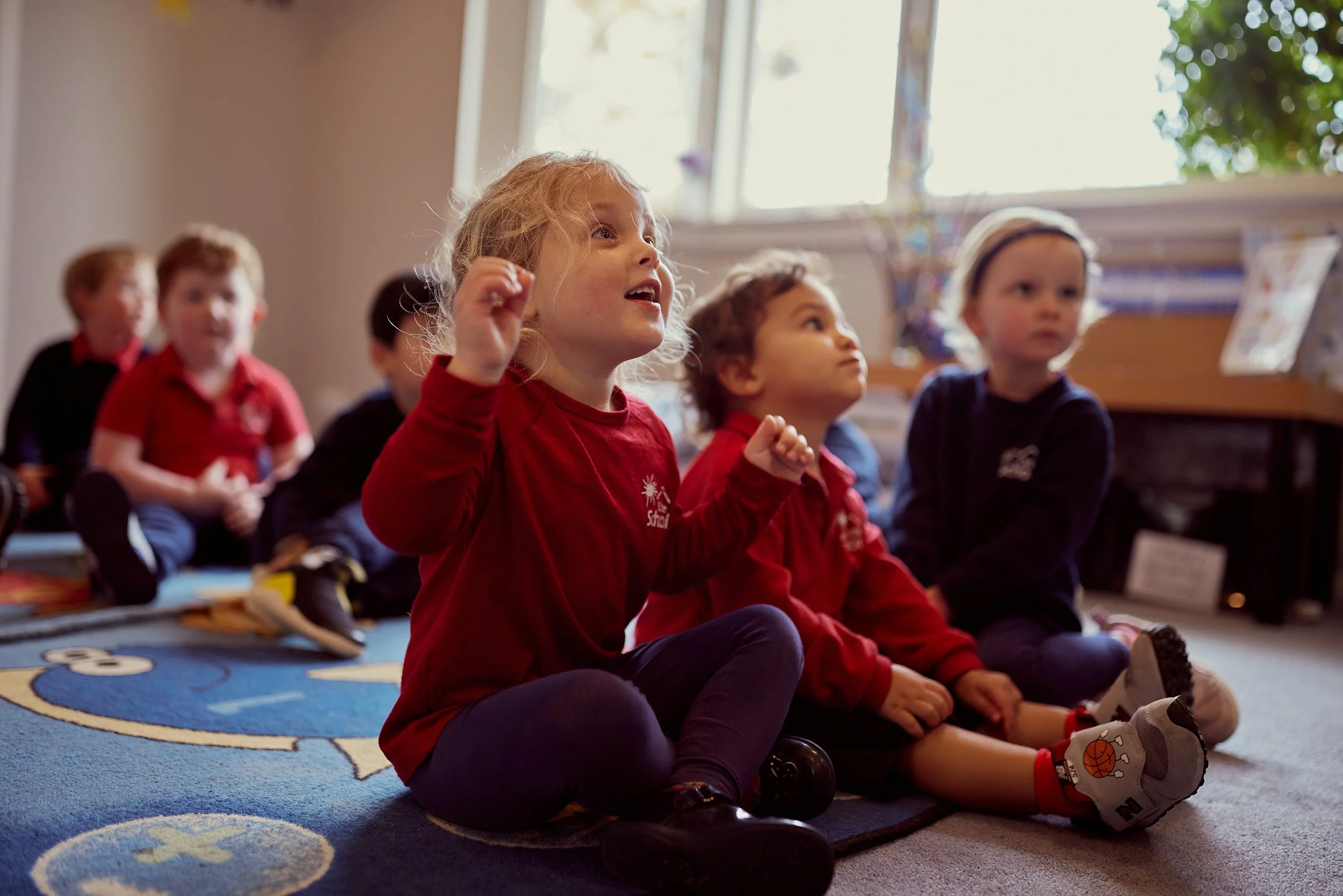 A group of children sitting and learning with the class