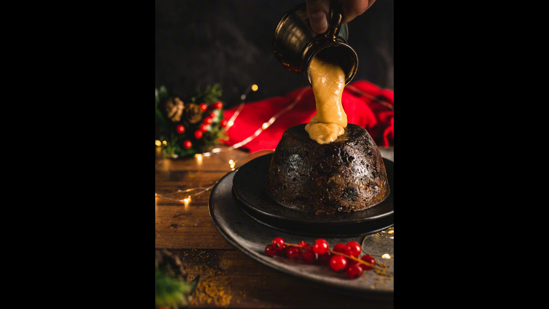 A cake with red icing dripping over the sides, placed on a glass stand, with a large knife inserted into the top, in a dark setting with colorful string lights in the background.
