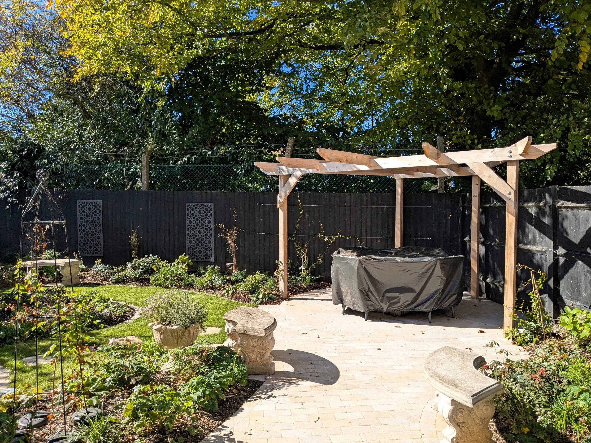 Garden with a pergola and light coloured patio