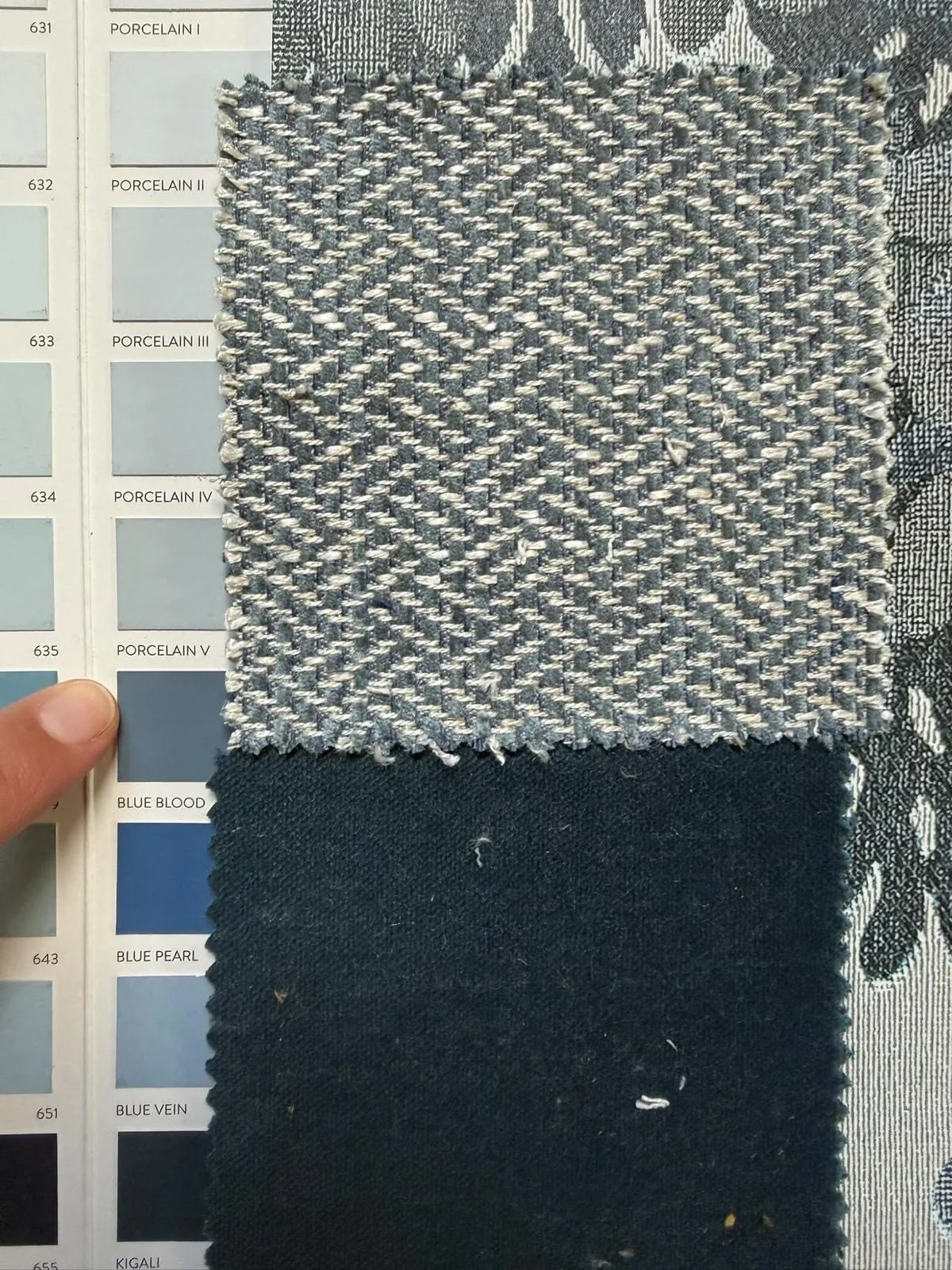 In progress: close-up of blue and navy fabric samples next to a paint card