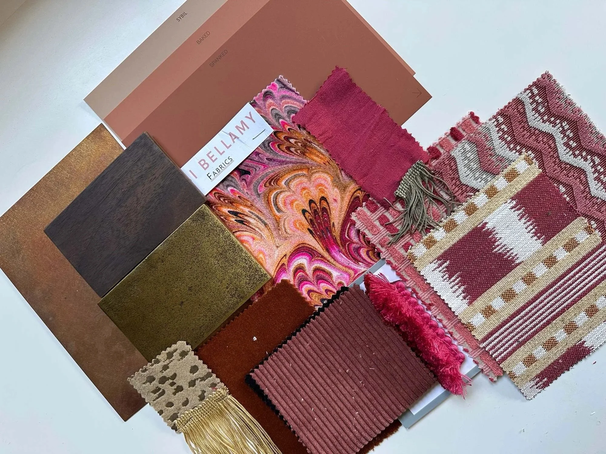 Design: fabric, trim and finish samples for the bar, in pinks, reds and brass