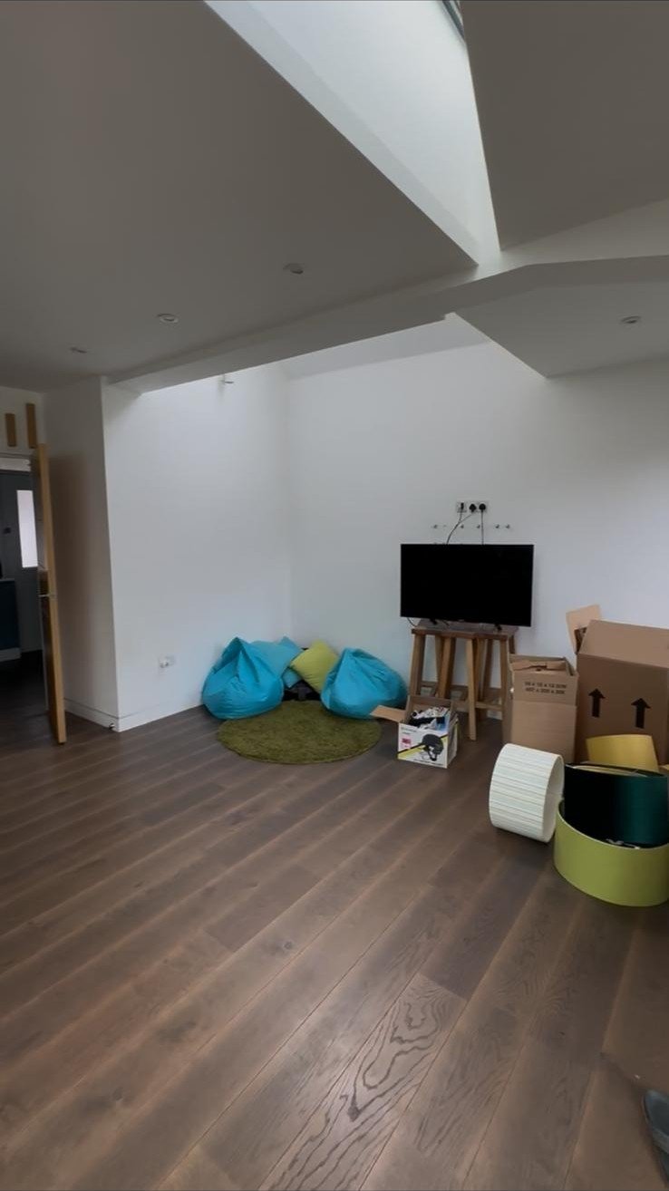 Before: the sitting area of the open-plan room, with a TV on a stand