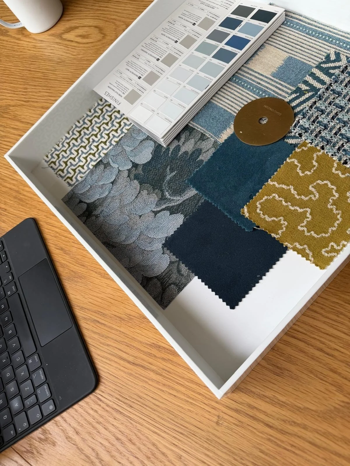 In progress: fabric samples in blues, navy and mustard, with a paint card
