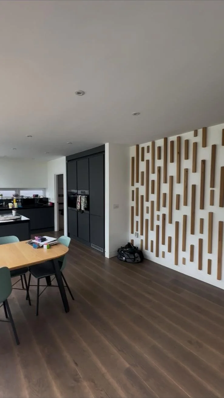Before: the dining area, dark kitchen units and a slatted timber wall