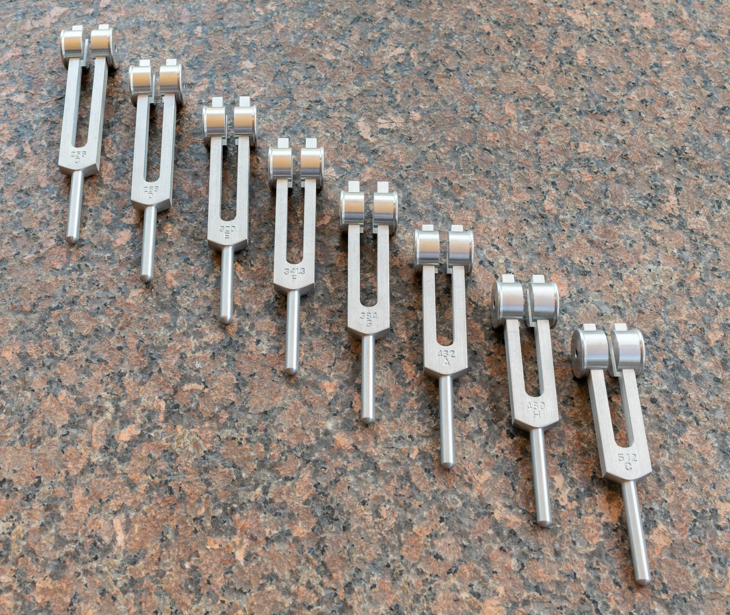 A set of tuning forks lined up diagonally