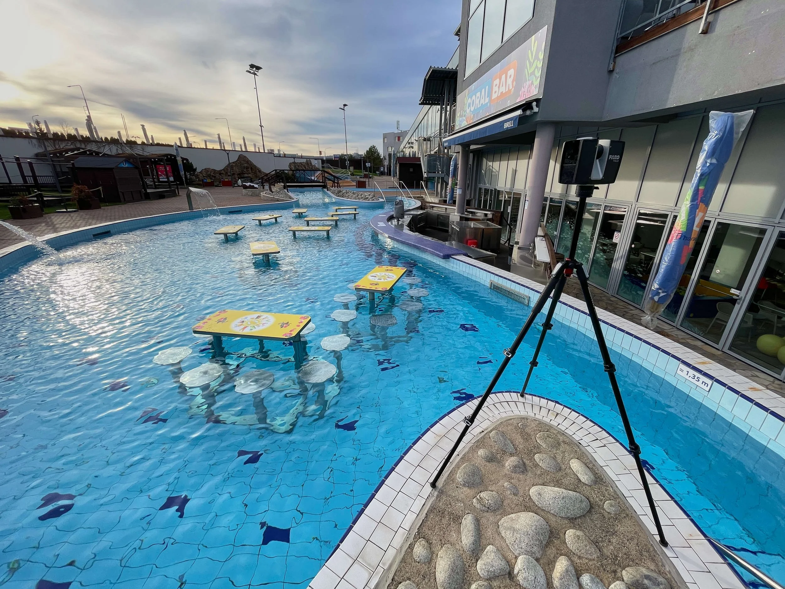 Pozemni laserovy skener na stativu pri zamereni venkovniho bazenu, prilehlych ploch a fasady budovy. Data slouzi pro dokumentaci skutecneho stavu a pro tvorbu presneho 3D modelu arealu Aquapalace Praha.