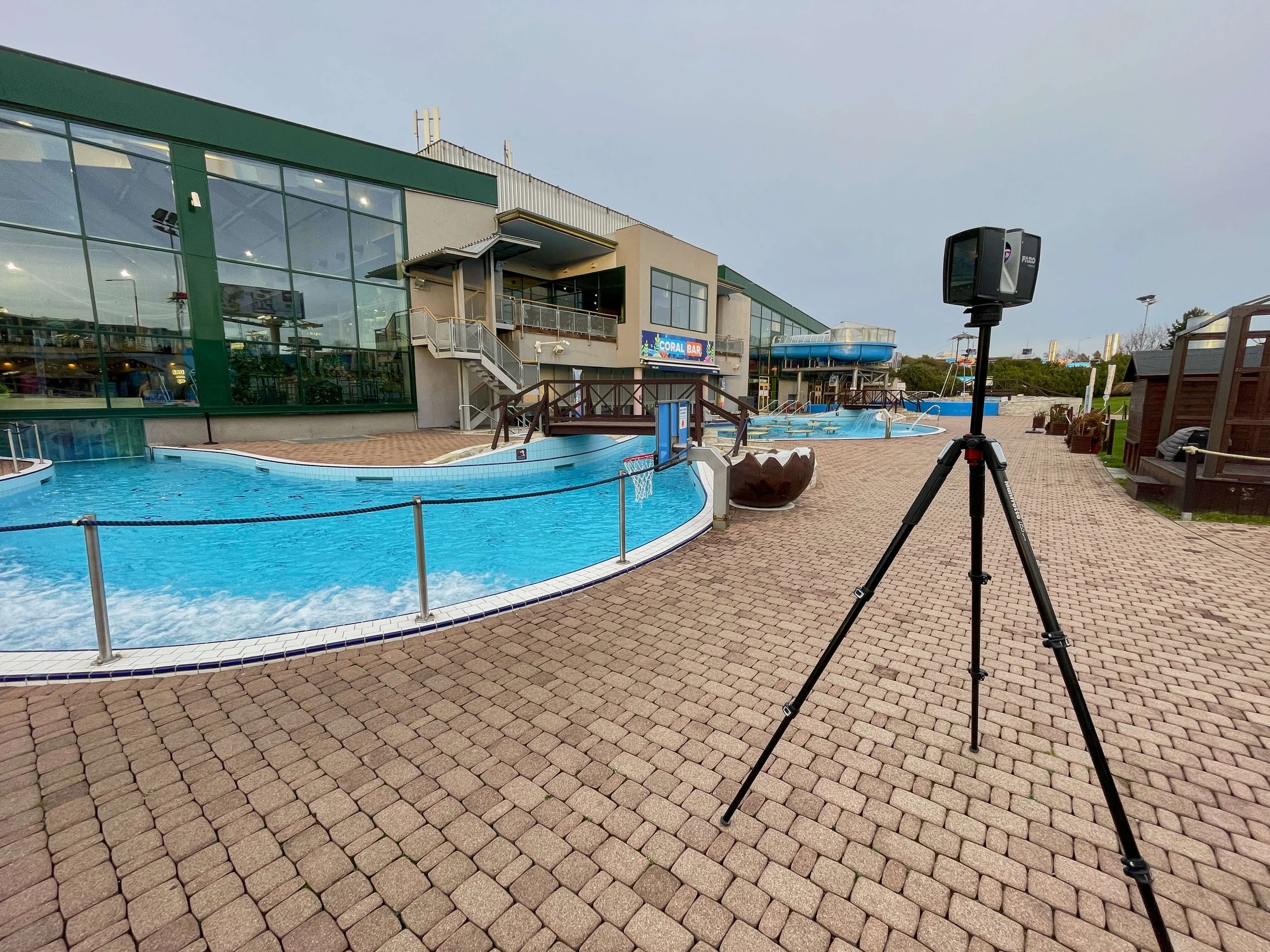 Pozemni laserovy skener na stativu pri zamereni fasady a prilehleho venkovniho arealu Aquapalace Praha. Skeny zachycuji geometrii objektu, bazenove casti a komunikace pro tvorbu presneho 3D modelu skutecneho stavu.
