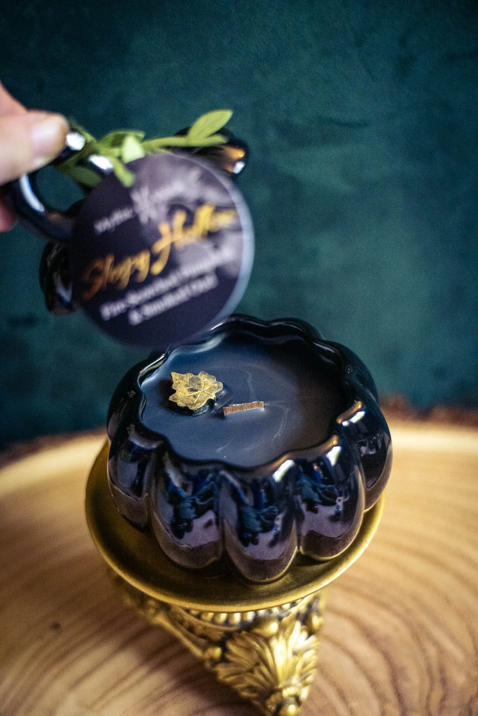 Wood-wick candle in a Black Pumpkin shaped jar labeled "Sleepy Hollow"