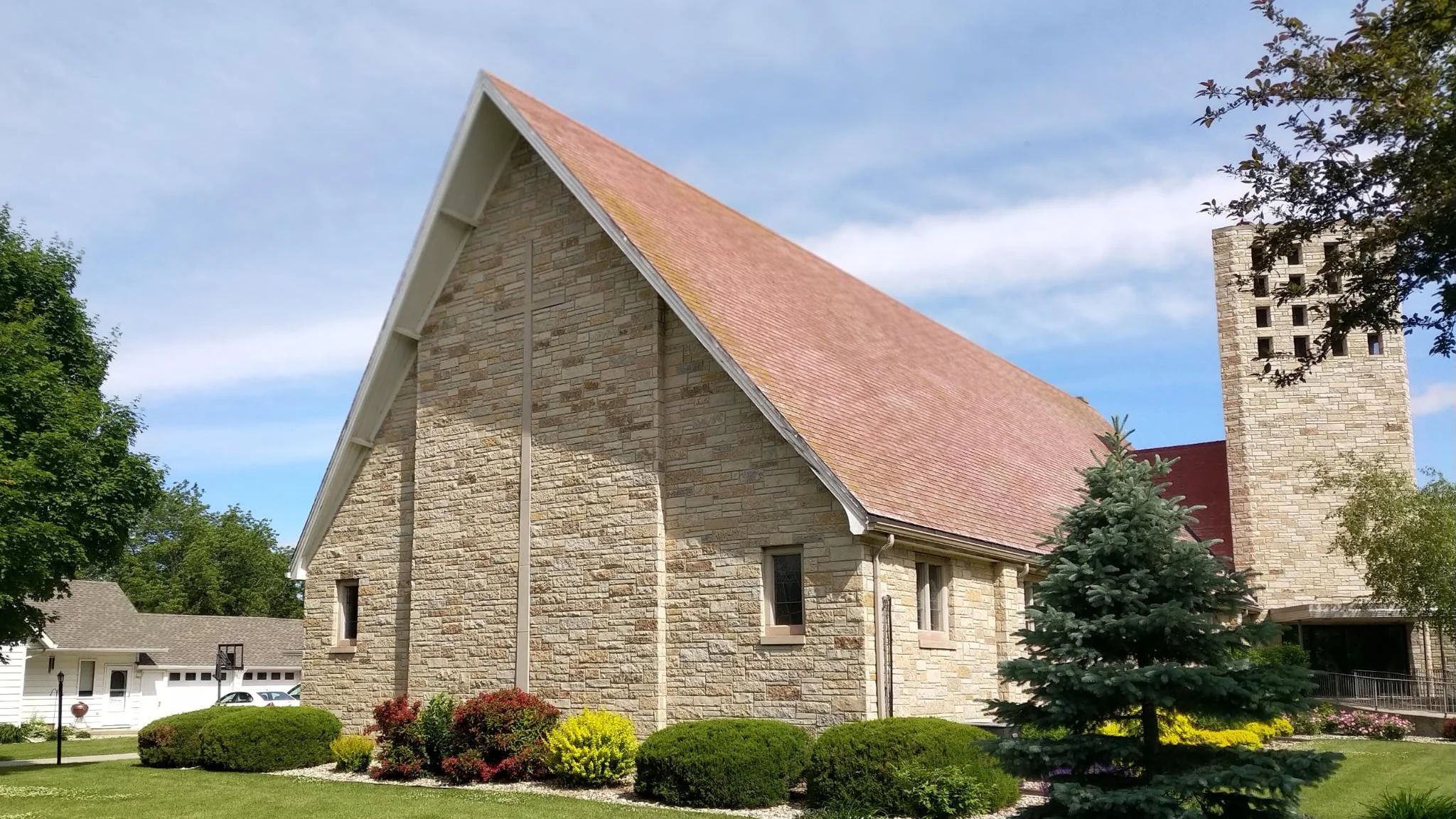 First Reformed Church in Edgerton: a stone sanctuary with a steep roof and bell tower on a summer day.