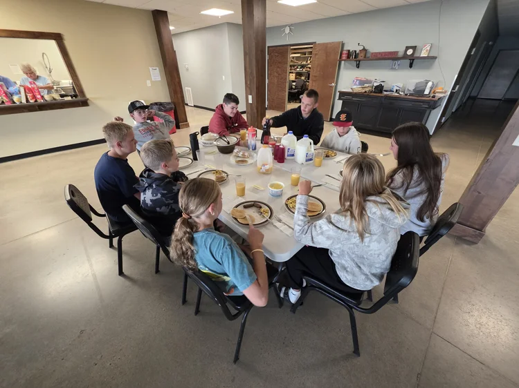 Students sharing a meal around a long table