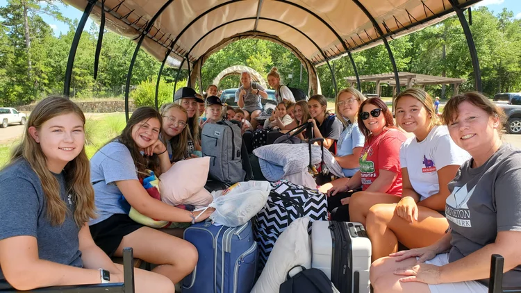 Students riding together on a covered hay wagon