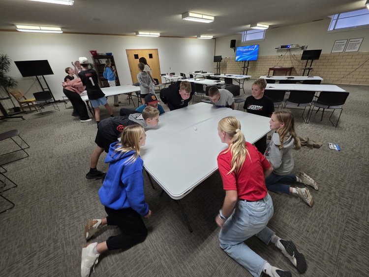 Students playing a game on the floor of a large room