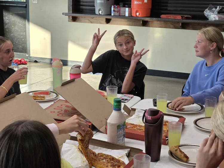 Students enjoying pizza around a table