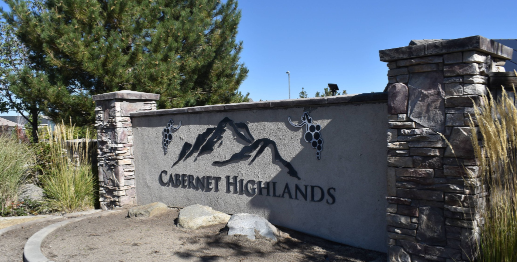 Cabernet Highlands neighborhood entrance sign surrounded by trees and dry landscaping.