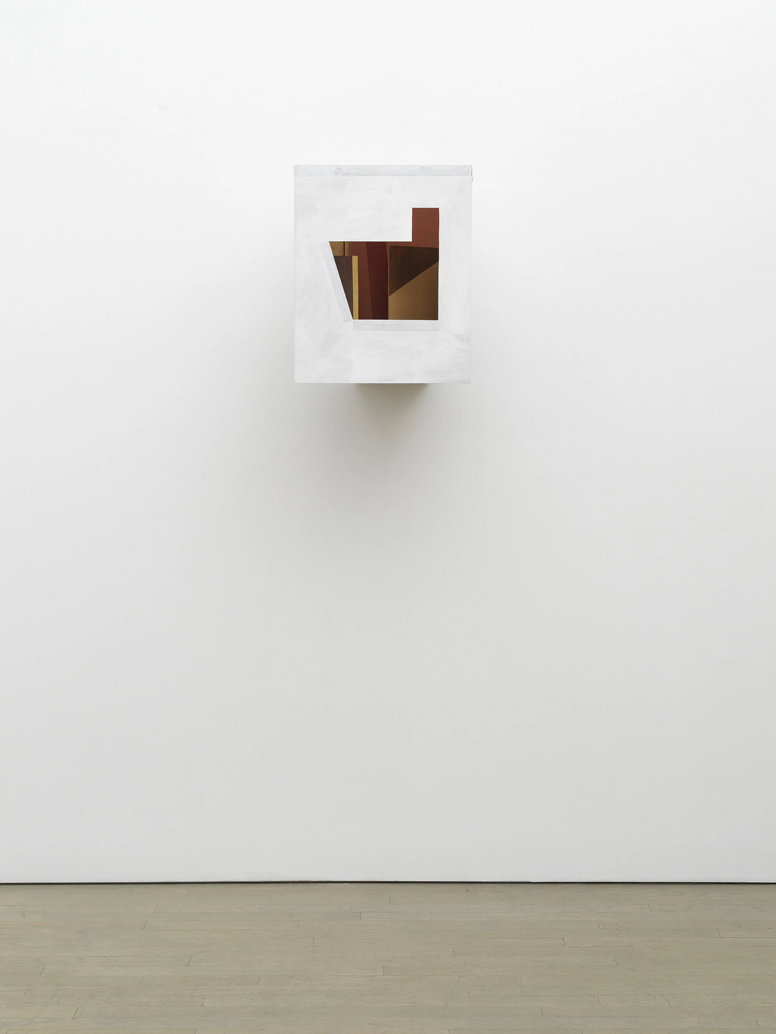 A plain white wall in an art gallery with a single abstract painting and a wooden floor.
